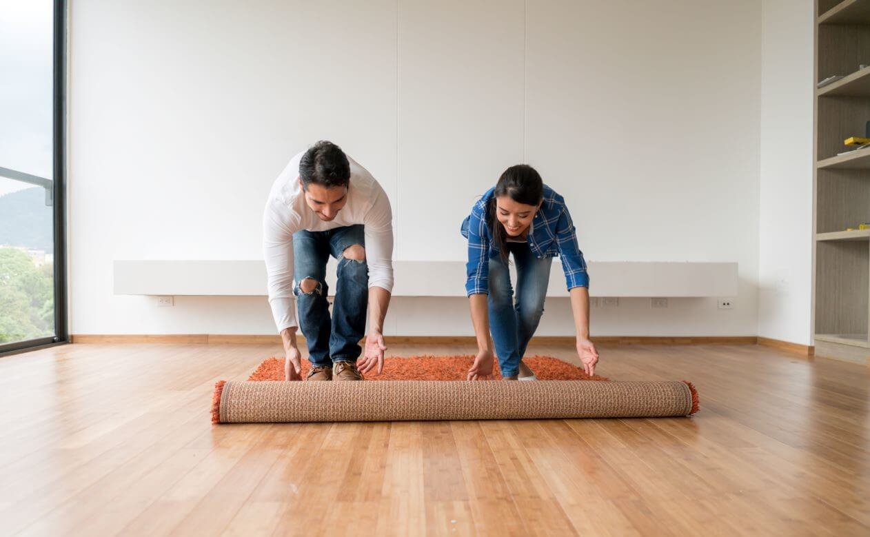 Two people rolling out a carpet