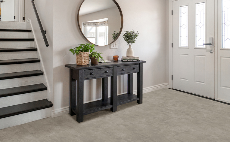 natural stone look luxury vinyl tile in modern entryway with wood accents