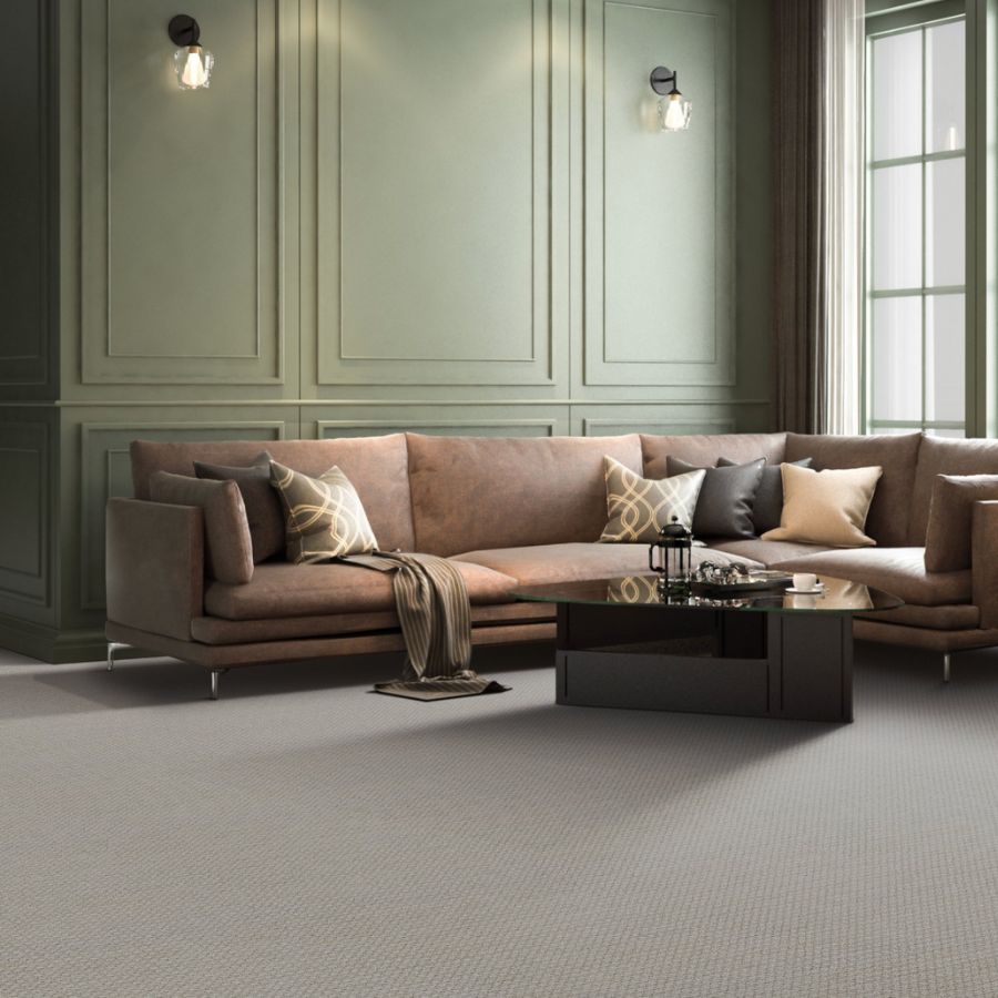 grey carpet in a living room with green accent wall and leather couch
